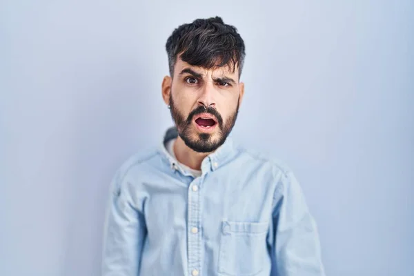 Junger Hispanischer Mann Mit Bart Steht Vor Blauem Hintergrund Schockgesicht — Stockfoto