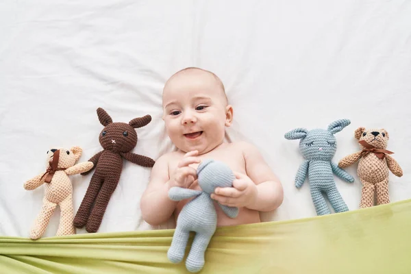 Urocze Kaukaskie Dziecko Uśmiecha Się Pewnie Leżąc Łóżku Lalkami Sypialni — Zdjęcie stockowe