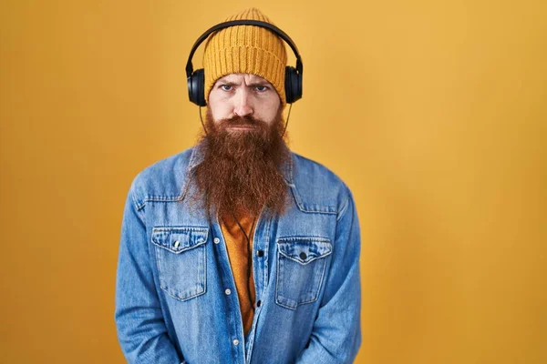 Καυκάσιος Άντρας Μακριά Γενειάδα Ακούει Μουσική Χρησιμοποιώντας Ακουστικά Σκεπτικός Και — Φωτογραφία Αρχείου
