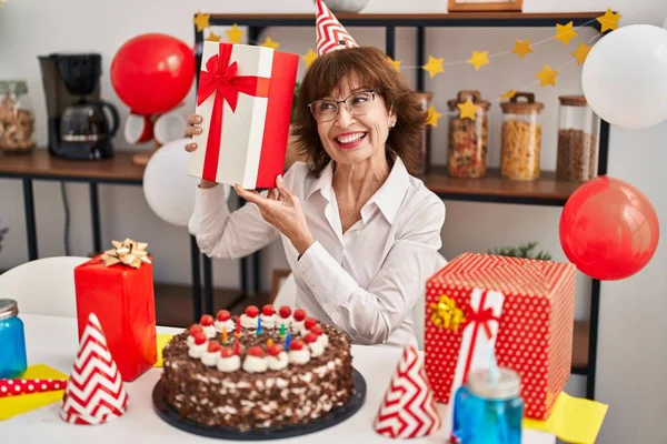 Kobieta Średnim Wieku Świętuje Urodziny Trzymając Prezent Domu — Zdjęcie stockowe