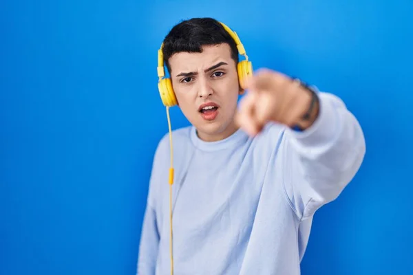 Δυαδικό Πρόσωπο Που Ακούει Μουσική Χρησιμοποιώντας Ακουστικά Που Δείχνουν Δυσαρεστημένος — Φωτογραφία Αρχείου
