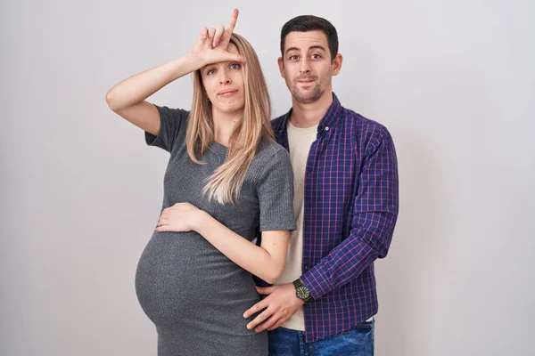 Casal Jovem Esperando Bebê Sobre Fundo Branco Zombando Pessoas Com — Fotografia de Stock