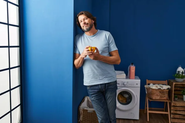 Middle Age Man Smiling Confident Drinking Coffee Laundry Room — ストック写真