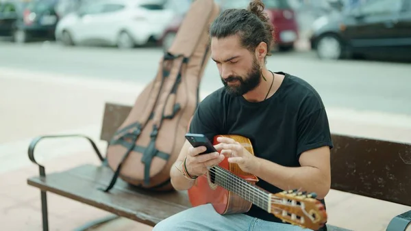 Νεαρός Ισπανός Μουσικός Κρατώντας Κλασική Κιθάρα Χρησιμοποιώντας Smartphone Στο Δρόμο — Φωτογραφία Αρχείου
