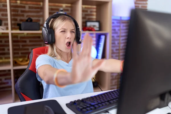 Νεαρή Καυκάσια Γυναίκα Που Παίζει Βιντεοπαιχνίδια Φορώντας Ακουστικά Κάνοντας Χειρονομία — Φωτογραφία Αρχείου