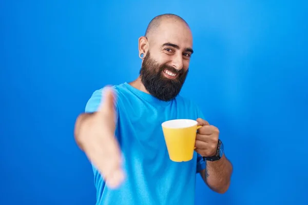 年轻的 留着胡子 纹身的他惊慌失措的男人喝着一杯咖啡 友善地握手致意和欢迎 成功的商业 — 图库照片