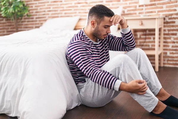 stock image Young hispanic man stressed sitting on floor at bedroom