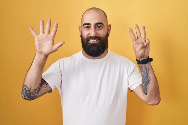 Молодой Латиноамериканец Бородой Татуировками Стоит Желтом Фоне Показывает Пальцами Номер — стоковое фото