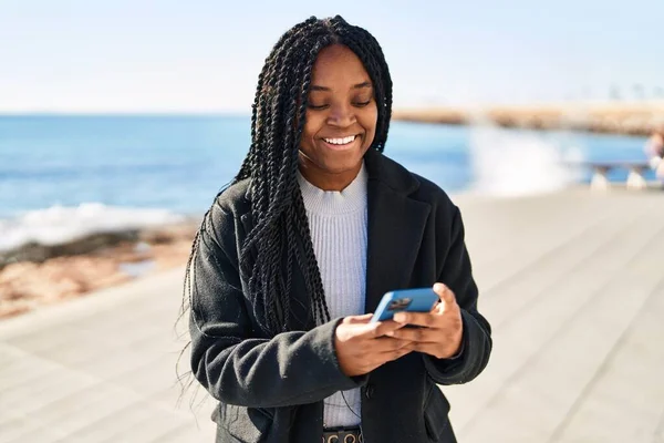 Afričanky Americká Žena Úsměvem Sebevědomě Pomocí Smartphone Moře — Stock fotografie