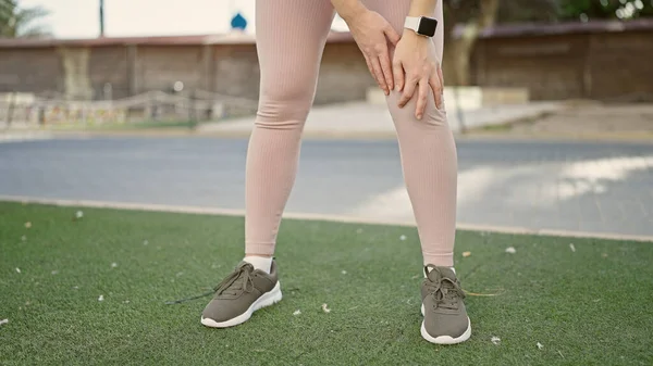 Spor Giyinen Genç Sarışın Kadın Parkta Dizine Dokunuyor — Stok fotoğraf