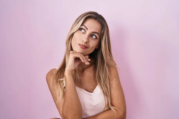 Young Blonde Woman Standing Pink Background Hand Chin Thinking Question —  Fotos de Stock