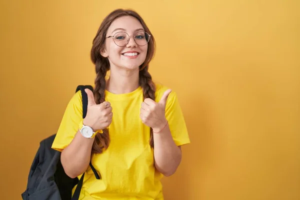 Jovem Mulher Caucasiana Vestindo Mochila Estudantil Sobre Amarelo Sinal Sucesso — Fotografia de Stock