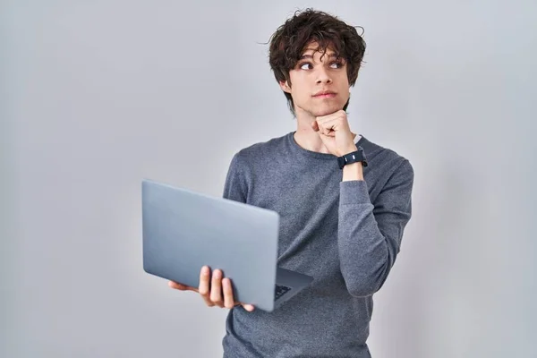 Jovem Trabalhando Usando Computador Laptop Rosto Sério Pensando Questão Com — Fotografia de Stock