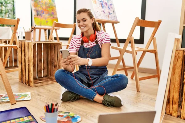 在艺术工作室用智能手机微笑自信的年轻女子 — 图库照片