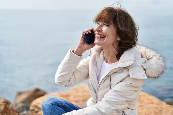 Orta Yaşlı Bir Kadın Deniz Kenarındaki Kayada Oturmuş Akıllı Telefondan — Stok fotoğraf