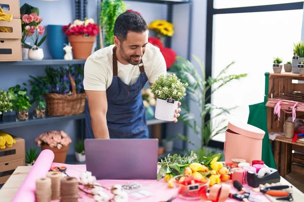 Young Hispanic Man Florist Using Laptop Holding Plant Pot Florist — Stockfoto
