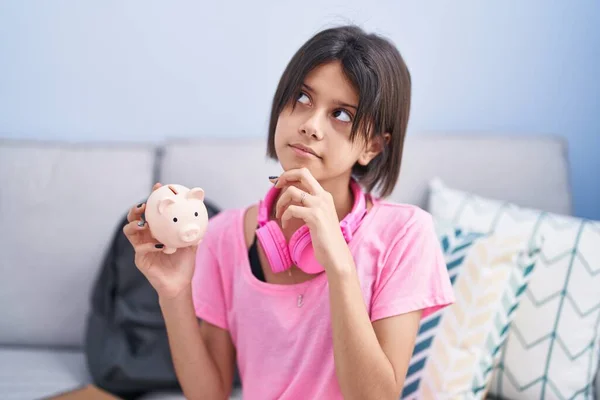 Menina Segurando Porquinho Banco Sério Rosto Pensando Questão Com Mão — Fotografia de Stock