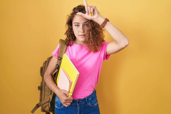 Young Caucasian Woman Wearing Student Backpack Holding Books Making Fun — Stock Photo, Image