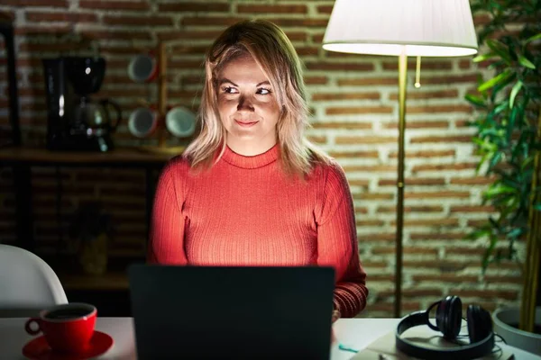 Mulher Loira Usando Laptop Noite Casa Sorrindo Olhando Para Lado — Fotografia de Stock