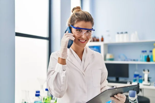 Young Blonde Woman Wearing Scientist Uniform Talking Smartphone Laboratory — Φωτογραφία Αρχείου
