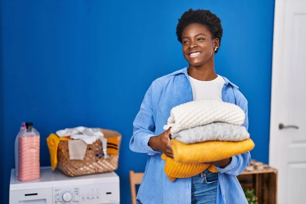 African American Woman Smiling Confident Holding Folded Clothes Laundry Room — Stock Photo, Image
