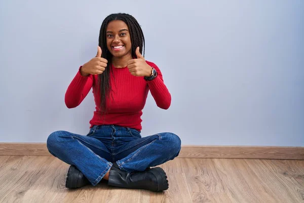 Joven Afroamericano Con Trenzas Sentado Suelo Casa Signo Éxito Haciendo —  Fotos de Stock