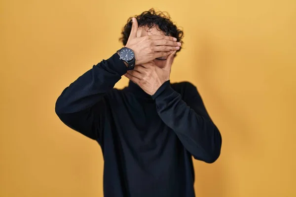 Homem Hispânico Sobre Fundo Amarelo Cobrindo Olhos Boca Com Mãos — Fotografia de Stock