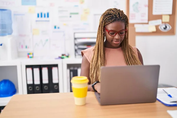 使用笔记本电脑在办公室工作的非洲裔美国女商人 — 图库照片