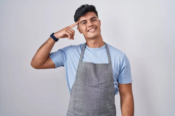 Hispanic Young Man Wearing Apron White Background Smiling Pointing Head — Stock Photo, Image