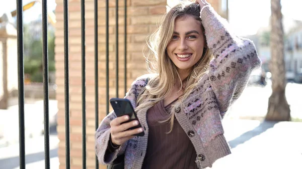 Молодая Блондинка Уверенно Улыбается Используя Смартфон Улице — стоковое фото