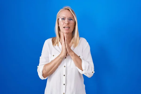 Young Caucasian Woman Standing Blue Background Begging Praying Hands Together — Stock Photo, Image