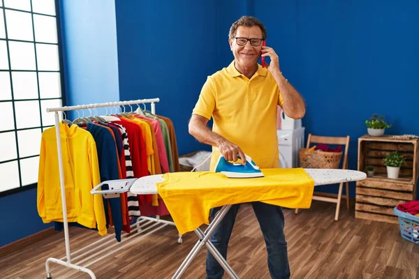 Middle Age Man Talking Smartphone Ironing Clothes Laundry Room — Zdjęcie stockowe