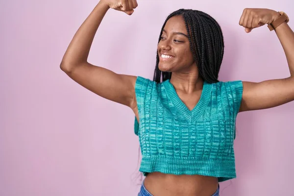 Jovem Afro Americana Com Tranças Sobre Fundo Rosa Mostrando Músculos — Fotografia de Stock