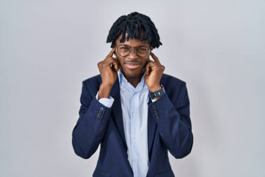 Gürültülü müzik sesi için siyah ceketli, kulakları parmaklarıyla kapatan Afrikalı genç bir adam. sağır kavramı. 