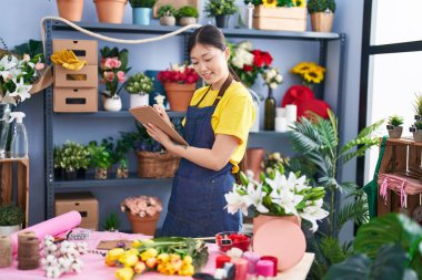 Chinese woman florist smiling confident writing on document at florist shop