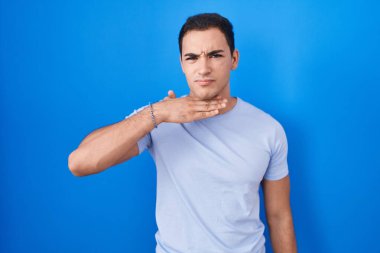 Mavi arka planda dikilen genç İspanyol adam bıçakla boğazı kesiyor, saldırganlığı şiddetle tehdit ediyor. 