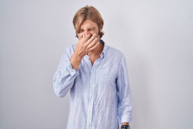 Beyaz arka planda duran beyaz bıyıklı beyaz bir adam pis ve iğrenç bir koku alıyor. Dayanılmaz bir koku. Parmakları burnunda nefesini tutuyor. Kötü kokuyor. 