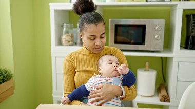 Anne ve oğlu yemek salonunda aynı masada oturuyorlar.
