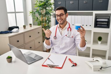 Sakallı, elinde pamuk tomurcukları olan, ağzı açık gülümseyen genç İspanyol doktor. 