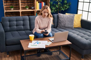 Evdeki kanepede oturan genç kadın.