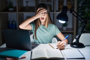 Genç kız gece geç saatte evde ödev yapıyor. Şoka girip yüzünü ve gözlerini kapatıyor. Utanmış bir ifadeyle parmaklarından bakıyor.. 