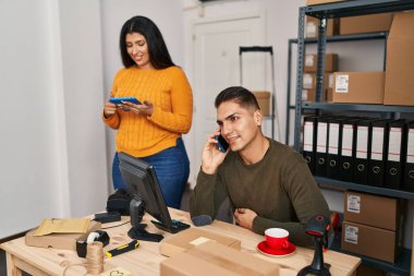 Man and woman ecommerce business workers talking on the smartphone at ecommerce office