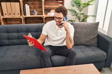 Psikoloji merkezindeki akıllı telefon okuma dokümanından konuşan genç İspanyol erkek psikolojisi.
