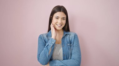 Young beautiful hispanic woman smiling confident standing over isolated pink background