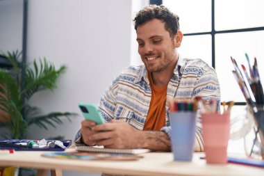 Sanat stüdyosunda akıllı telefon çizimi yapan genç bir İspanyol sanatçı.