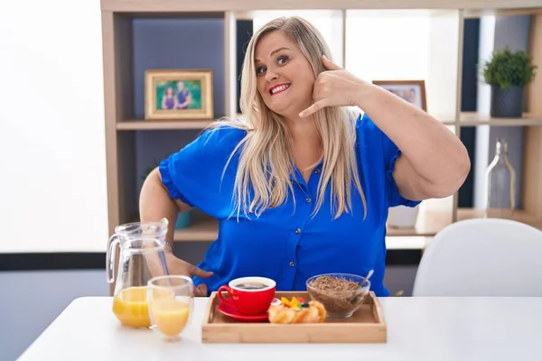 Caucasian Size Woman Eating Breakfast Home Smiling Doing Phone Gesture — Stock Photo, Image