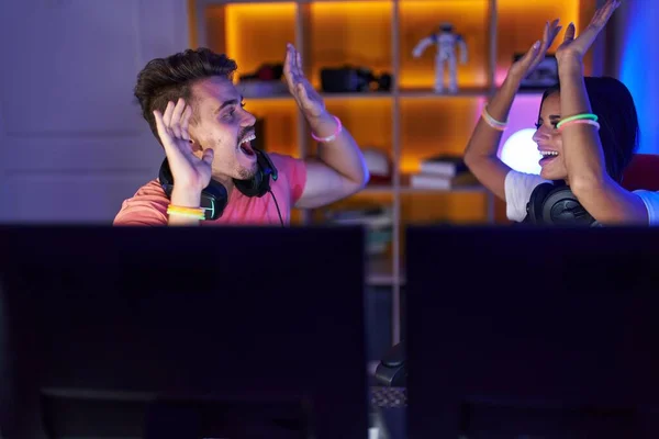 男男女女在游戏室玩赢者表情的电子游戏 — 图库照片