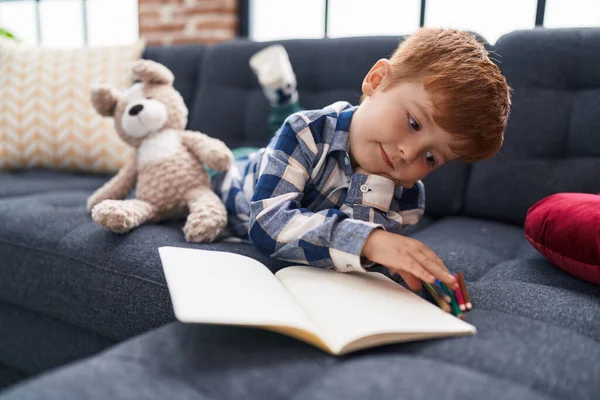Liebenswertes Kleinkind Zeichnet Auf Notizbuch Das Hause Auf Dem Sofa — Stockfoto