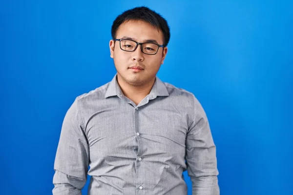 Mavi Arka Planda Duran Genç Çinli Adam Yüzünde Ciddi Bir — Stok fotoğraf