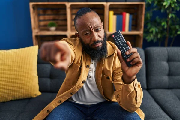 Hombre Afroamericano Sosteniendo Control Remoto Televisión Señalando Con Dedo Cámara —  Fotos de Stock